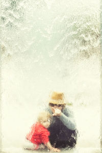 Mother and daughter behind glass wall