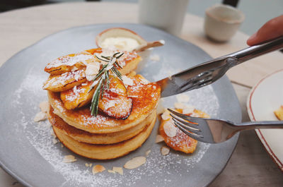 Close-up of forks on pancake in plate on table