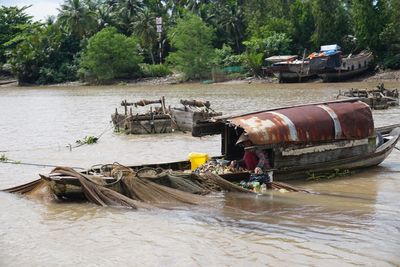 Boats in water against trees