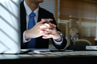 Midsection of businessman using mobile phone