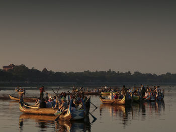 Boats moored in lake against clear sky