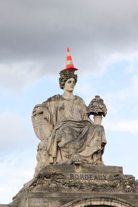 Statue representing bordeaux on the place de la concorde in paris with a traffic cone on the top 