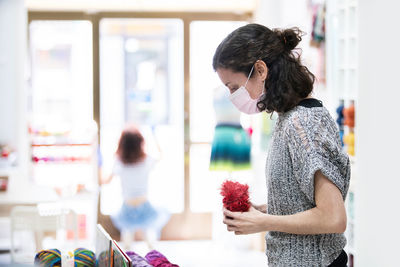 Woman holding thread standing at home