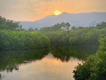 Scenic view of lake against sky at sunset