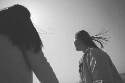 Low angle view of woman standing against sky