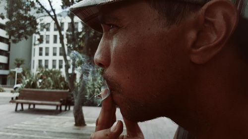 Close-up of young man smoking at park