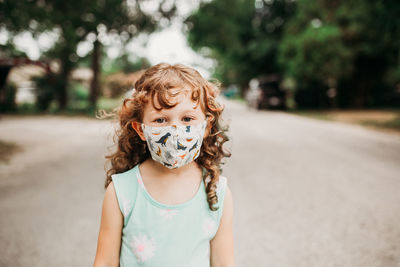 Young girl standing outside in neighborhood wearing homemade mask