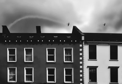 Residential building against sky with vintage aeroplane