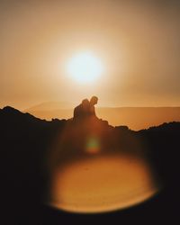 Silhouette of people on mountain against sky