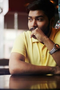 Thoughtful young man sitting at table