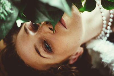 Close-up portrait of young woman lying down