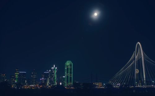 Illuminated city against sky at night