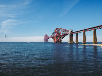 View of bridge over calm sea against sky