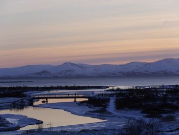 Scenic view of frozen lake against sky during sunset