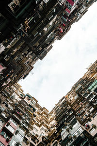 Low angle view of buildings against cloudy sky