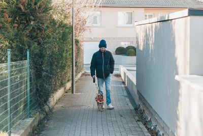 Rear view of man walking on footpath