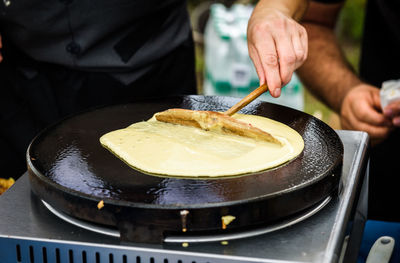 Close-up of person preparing food on stove