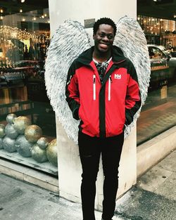 Portrait of young man standing at store