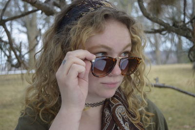 Close-up of woman looking away while standing at field