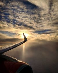 Airplane flying against sky during sunset