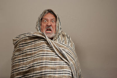 Portrait of mid adult man standing against wall