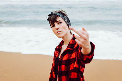 Portrait of young woman standing on beach