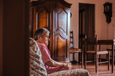 Midsection of woman sitting on chair at home