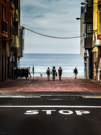 People by sea against sky in city