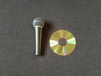 High angle view of microphone with dvd on table