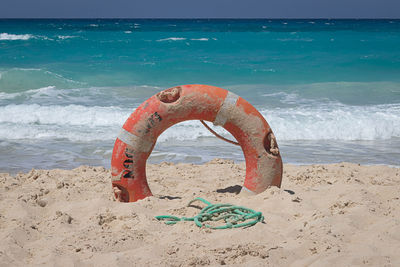 Lifeguard hut on shore at beach against sky