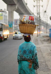 Rear view of woman carrying basket on head