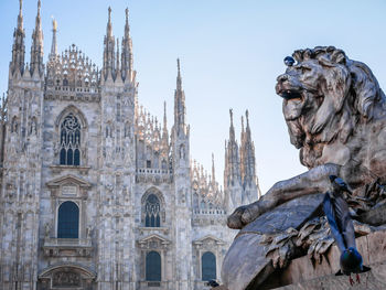 Low angle view of statues on building against sky