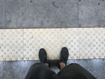 Low section of man standing on road