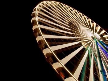 Low angle view of illuminated ferris wheel against sky at night