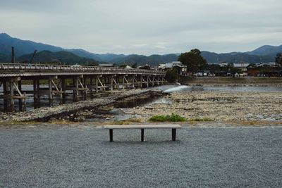 Bridge over river against sky in city