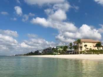 Buildings by sea against sky