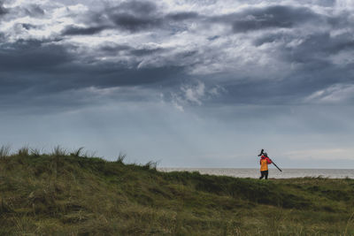 Man standing on field against sky