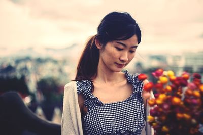 Young woman standing against sky