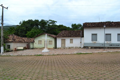 Cross on sidewalk against houses in village