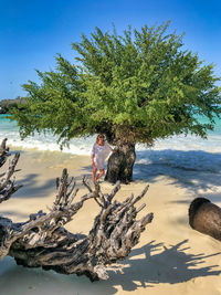 Full length of woman standing on beach against sky