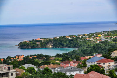 High angle view of townscape by sea against sky