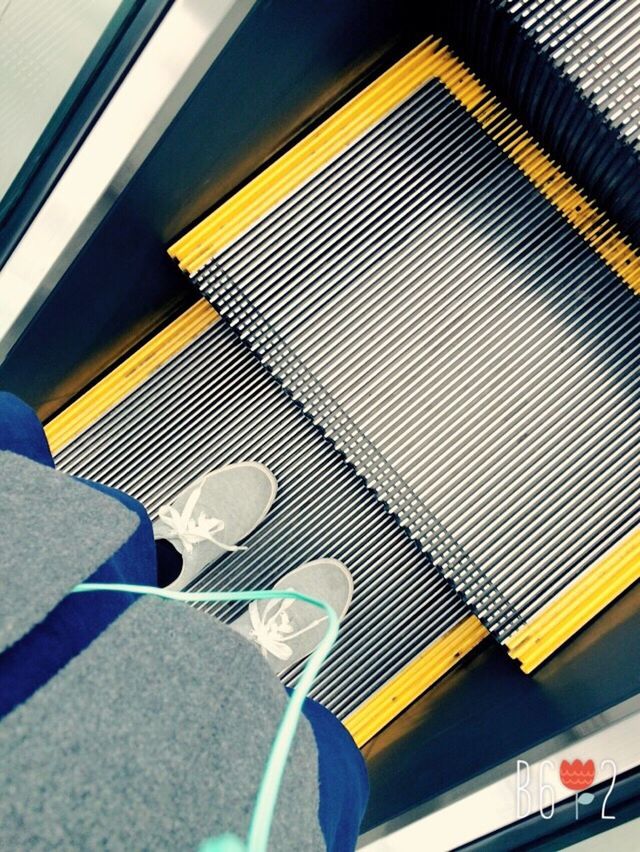 indoors, escalator, low section, person, steps, lifestyles, steps and staircases, men, shoe, high angle view, modern, technology, personal perspective, low angle view, yellow, staircase, transportation, convenience