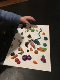 High angle view of hand playing with clay on table