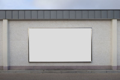 Close-up of white wall with building in background