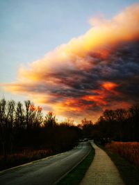 Empty road against sky during sunset