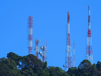 Low angle view of communications tower against clear blue sky