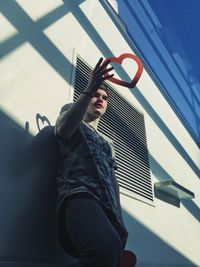 Low angle view of young man against building