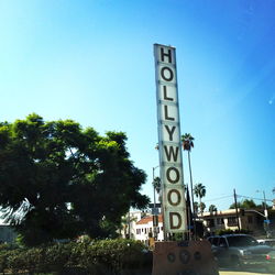 Low angle view of sign by building against clear sky