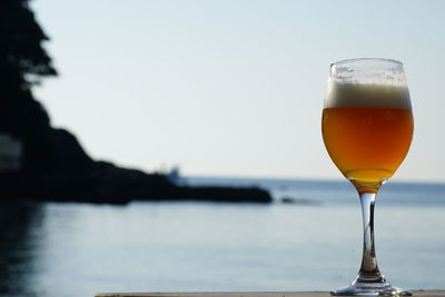 Close-up of beer glass against clear sky