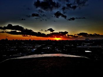 Silhouette city against sky during sunset